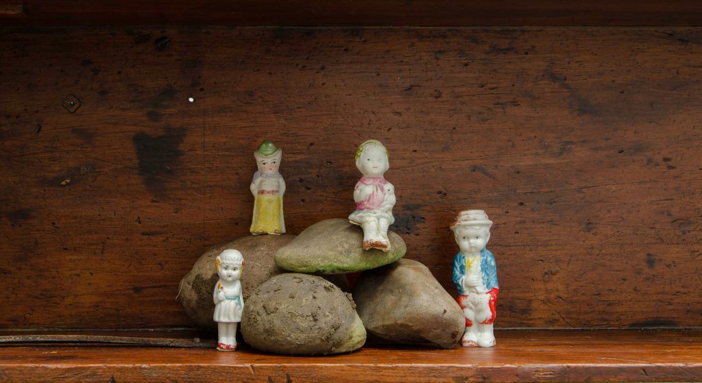 Four tiny toy figures and a pile of rocks